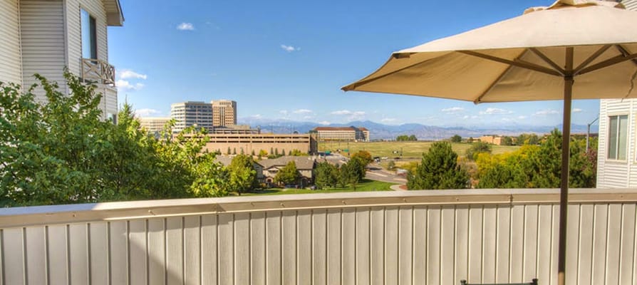 Panoramic view from a balcony with trees and urban landscape