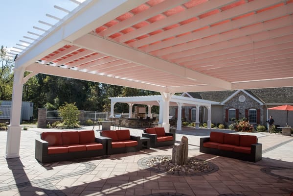 Outdoor seating area with red couches under a pergola