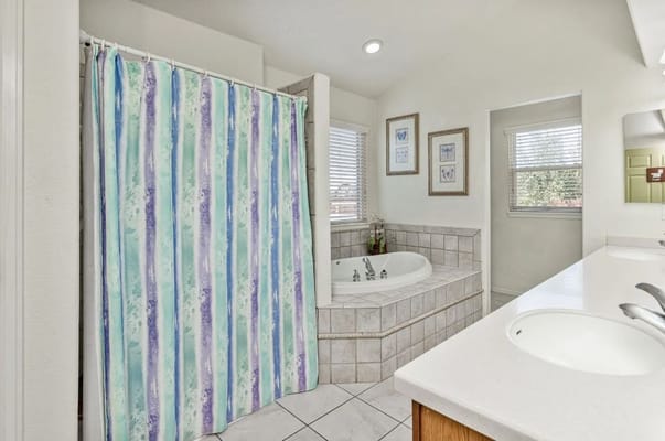 Comfortable bathroom with a shower, soaking tub, and natural light