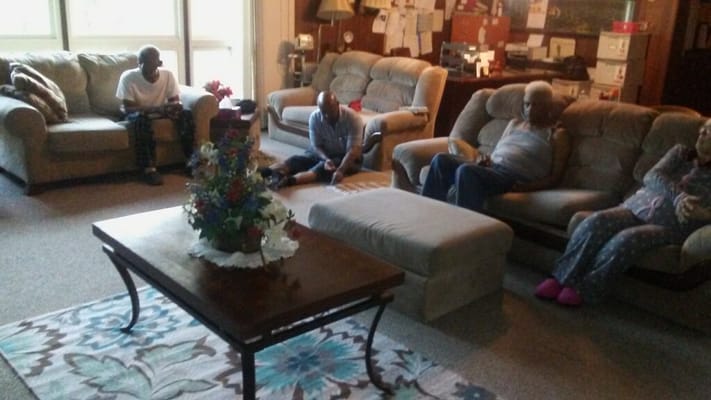 Residents relaxing in the living room with a floral centerpiece