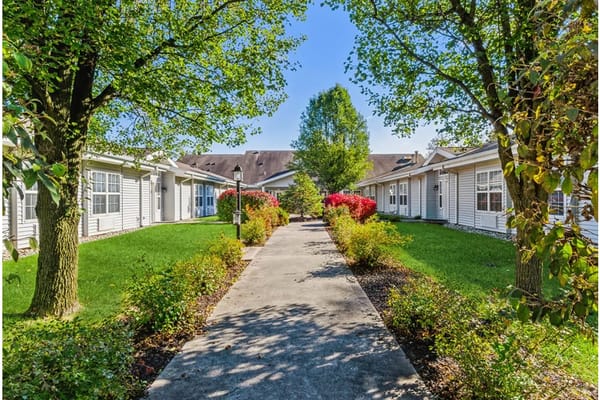 A landscaped garden path surrounded by greenery and flowers at Cedar Creek of Fort Wayne.