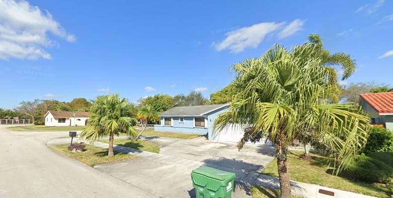 Exterior of Chanel Nursing Care ALF with palm trees and blue sky