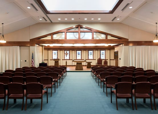 Interior view of a multi-purpose room with chairs and stained glass windows