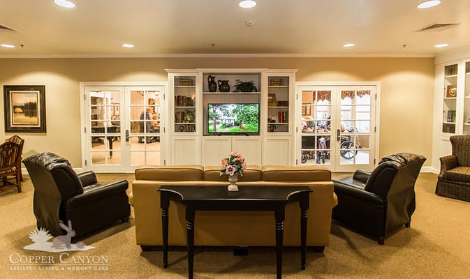 Lounge area with seating and a television in Copper Canyon Memory Care