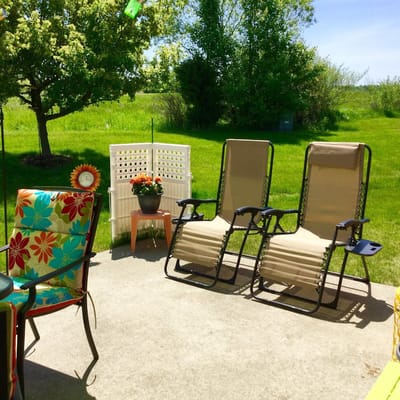 Outdoor seating area with lounge chairs and greenery
