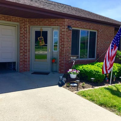 Exterior view of a facility entrance with landscaping and flag