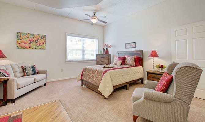 Spacious bedroom with a bed, armchair, and sofa in Cypress Palms