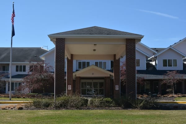 Main entrance of StoryPoint Grand Rapids West with flags and landscaping