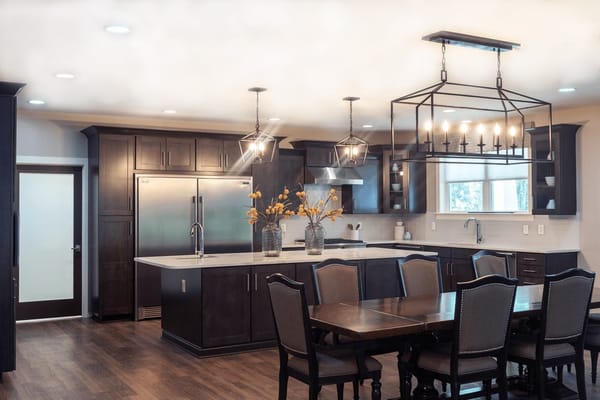 Modern kitchen with dark cabinetry and dining area