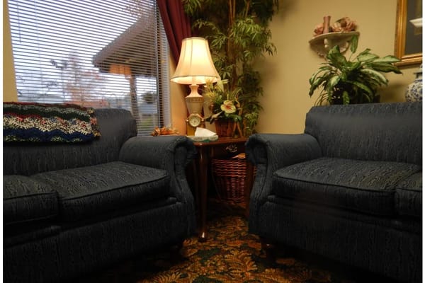 Comfortable seating area with a lamp and plants.