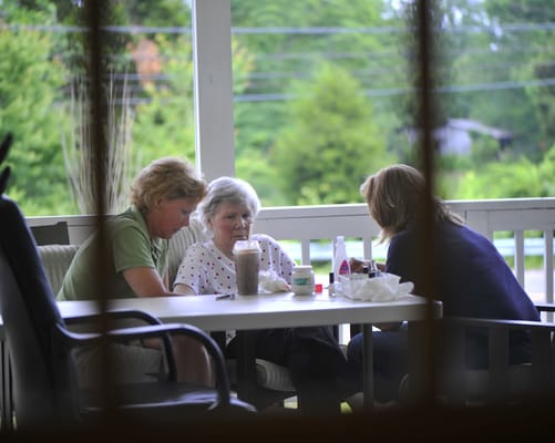 Residents and staff enjoying time together on a porch