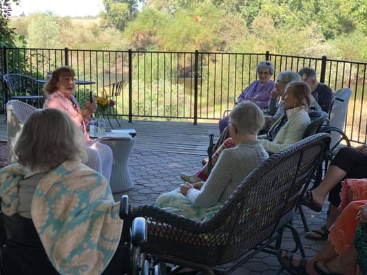 Residents enjoying an outdoor discussion led by a speaker.