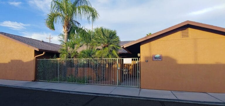 Front view of Groves Assisted Living facility with palm trees