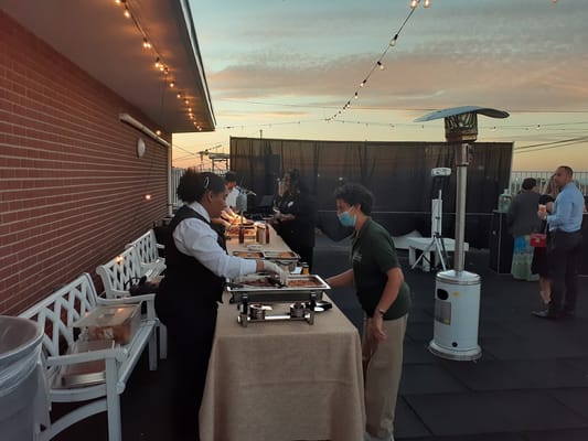 Staff serving food at an outdoor evening event
