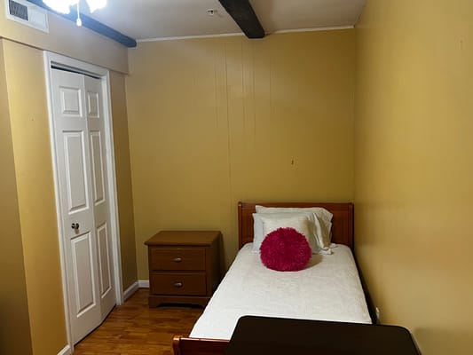 A simple, cozy bedroom with a single bed and a nightstand.