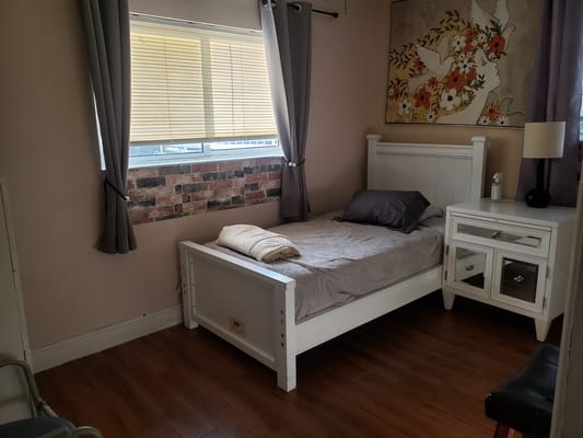 Bright bedroom featuring a single bed and a nightstand.