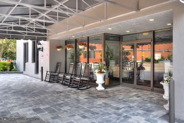 Welcoming entrance with rocking chairs and flowers at Lake Morton Plaza.
