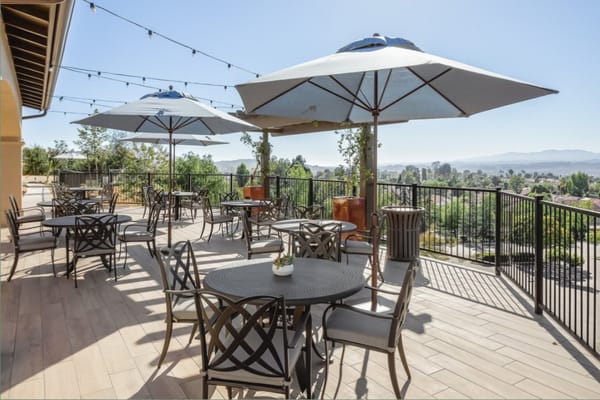 Sunny outdoor terrace with shaded seating and mountain view