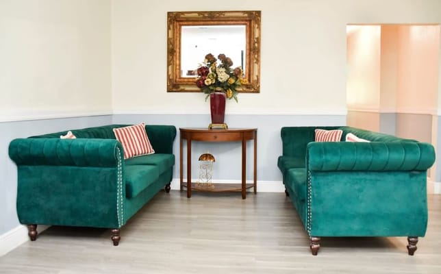 Green sofas and a decorative table in a living room setting