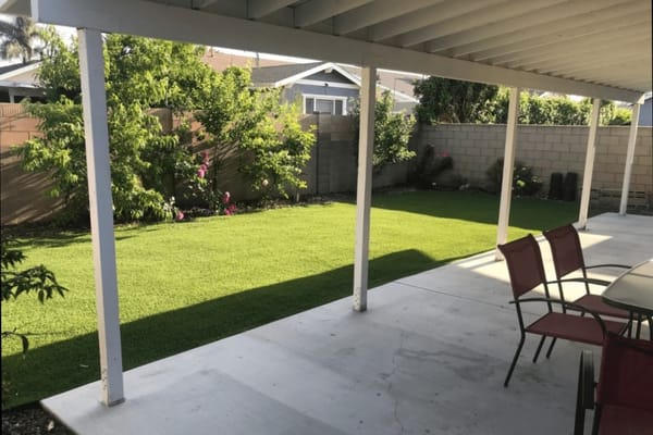 Outdoor space with landscaped grass and seating area