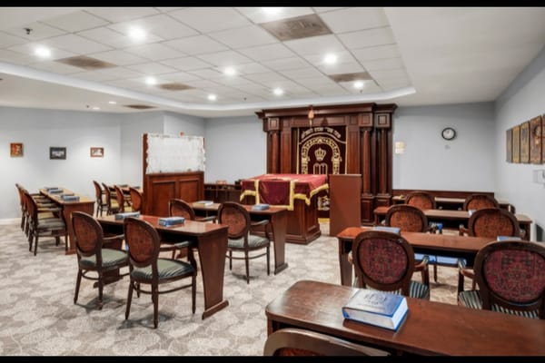 Interior view of the prayer room with wooden furnishings and a sacred area.