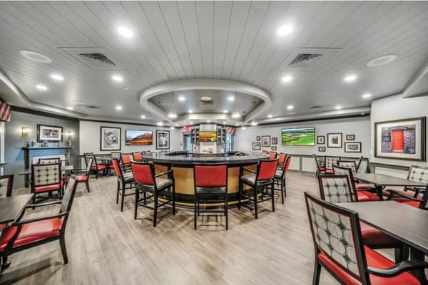 Modern dining area with tables and chairs, featuring artwork on the walls.