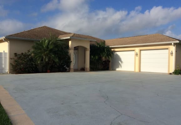 Front view of Naina's Angelic Hands Assisted Living Facility showing entrance and garage.