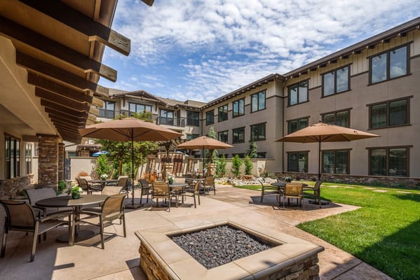 Outdoor seating area with umbrellas and a landscaped garden
