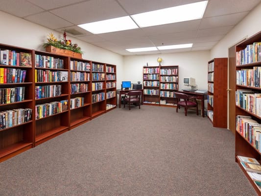 A view of the library with bookshelves and a computer station.