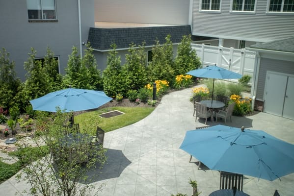 Outdoor seating area with blue umbrellas and flowers