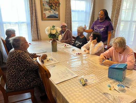 Residents participating in an indoor activity with staff assistance