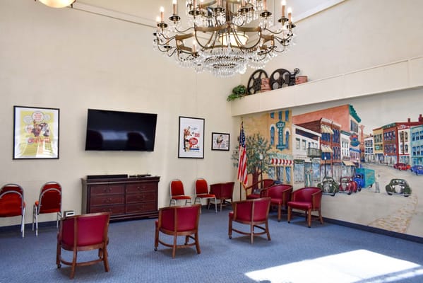 Interior view of a common area with chairs and a mural