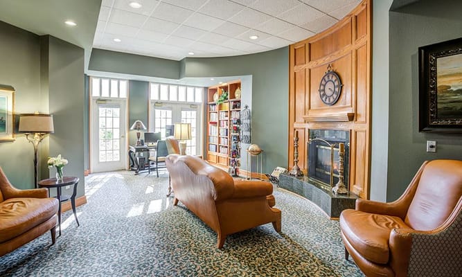 Bright living room with seating, fireplace, and bookshelves