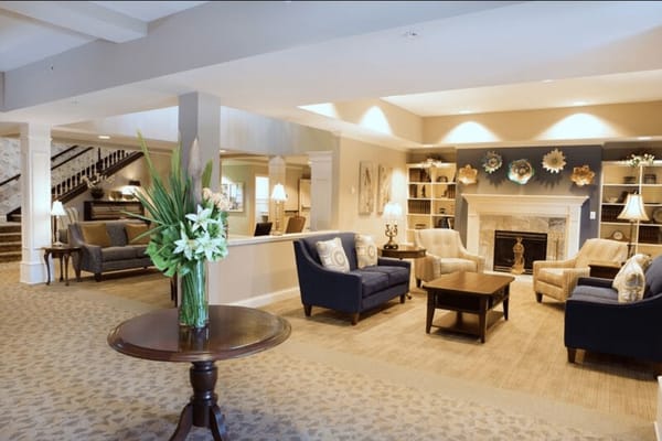 Cozy lounge area with seating, fireplace, and decorative shelves