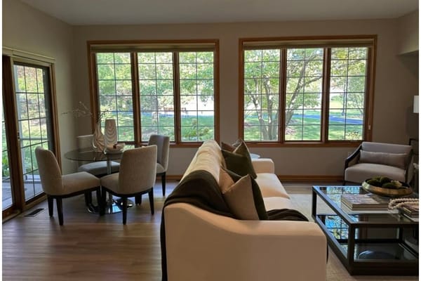 Cozy living room with large windows overlooking a garden.