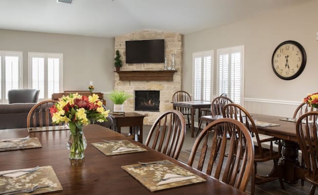 Bright dining area with wooden tables and flower arrangement