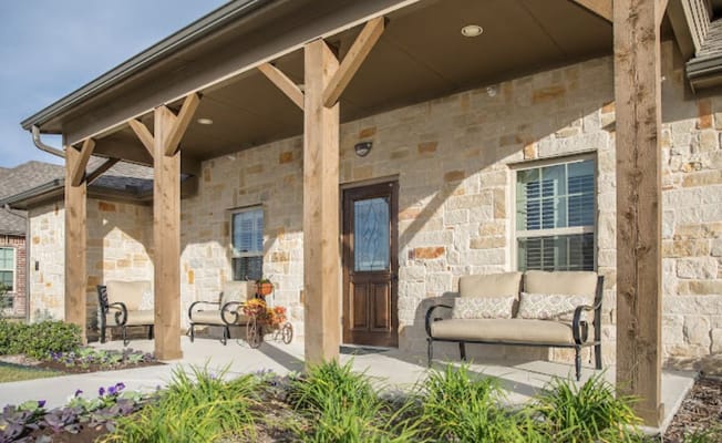 Covered porch area with seating at a senior living facility
