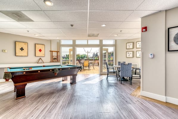 Bright common area with billiards table and outdoor seating
