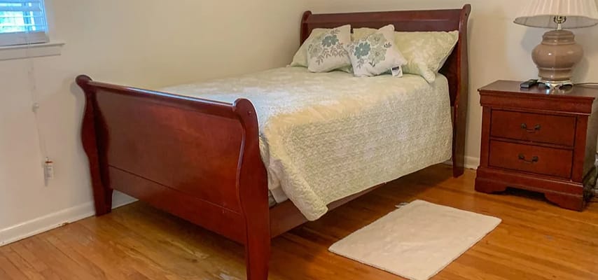 Inviting bedroom with a wooden bed, decorative pillows, and a nightstand.