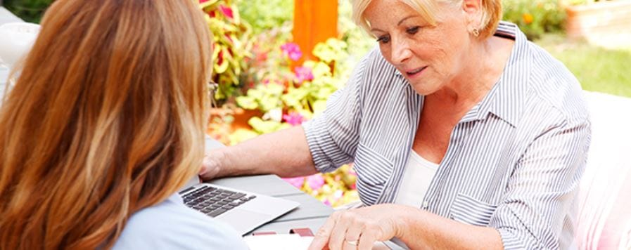 Senior resident and caregiver sharing ideas at a table