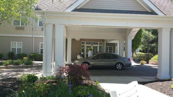 View of the entrance with a car and landscaped area.