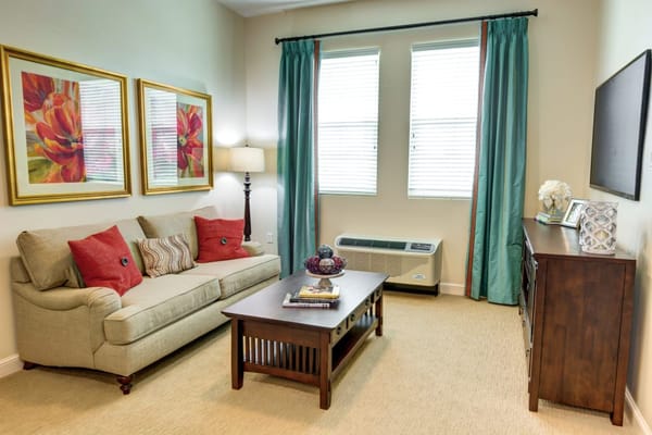 Spacious living room with a couch, coffee table, and large windows