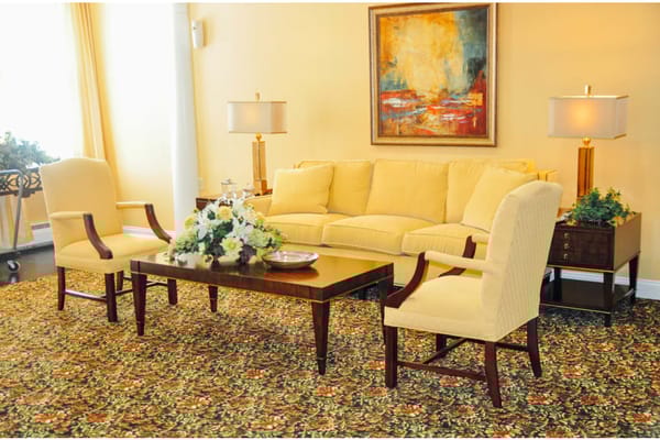 Bright and inviting living room with yellow furniture and a floral carpet