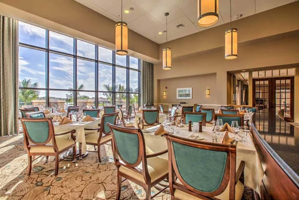 Elegant dining room with large windows and table settings