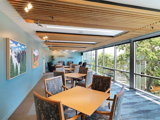 Bright common area with tables, chairs, and artwork at The Avant