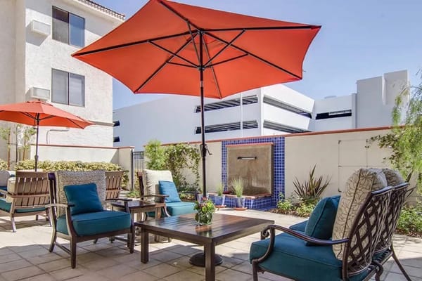 Cozy outdoor seating area with orange umbrellas and a water fountain