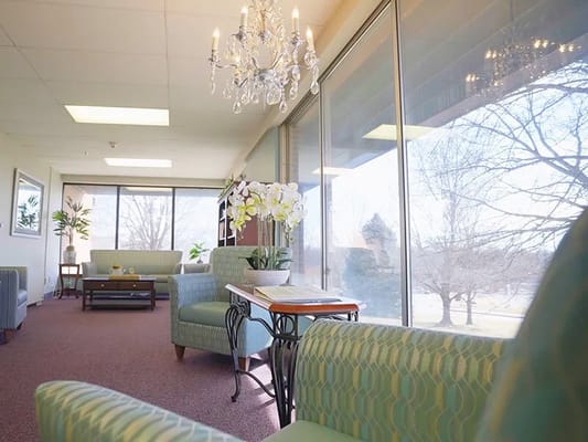 Lounge area with green chairs and large windows