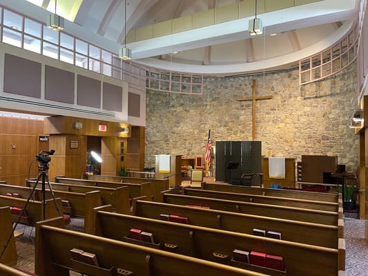 Interior view of a chapel with wooden pews and a cross