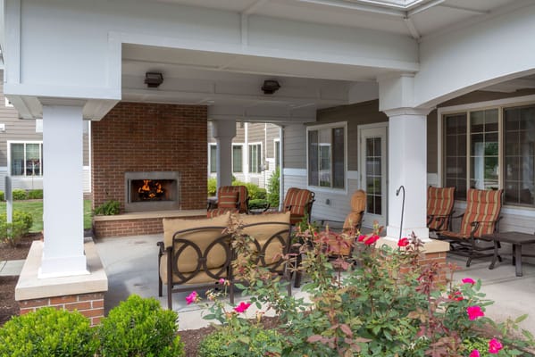 Outdoor seating area with fireplace and garden flowers