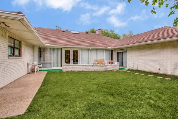 Outdoor courtyard with green lawn and seating area
